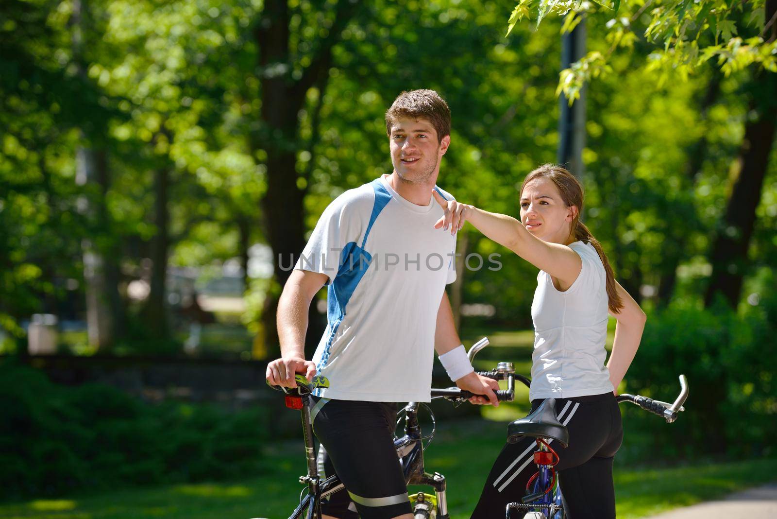 Happy couple riding bicycle outdoors by dotshock