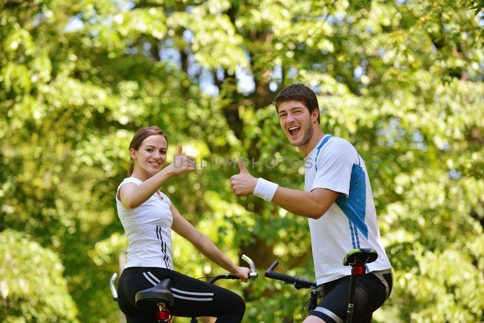 Happy couple riding bicycle outdoors by dotshock