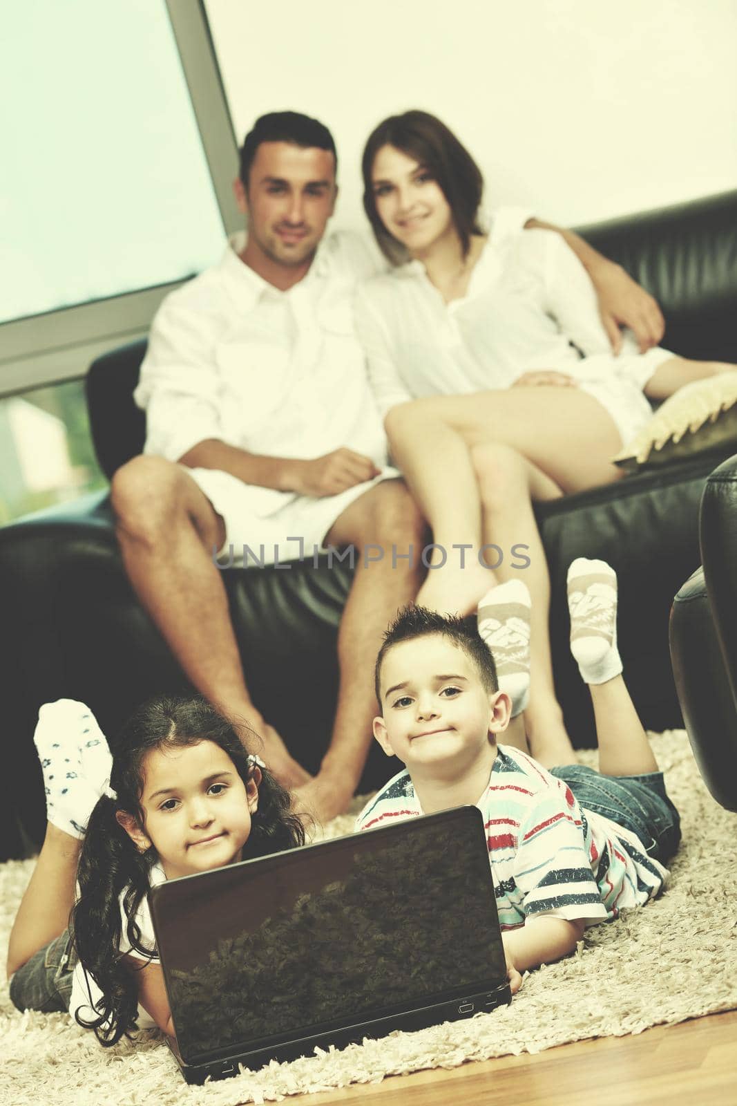happy young family have fun and working on laptop at home by dotshock