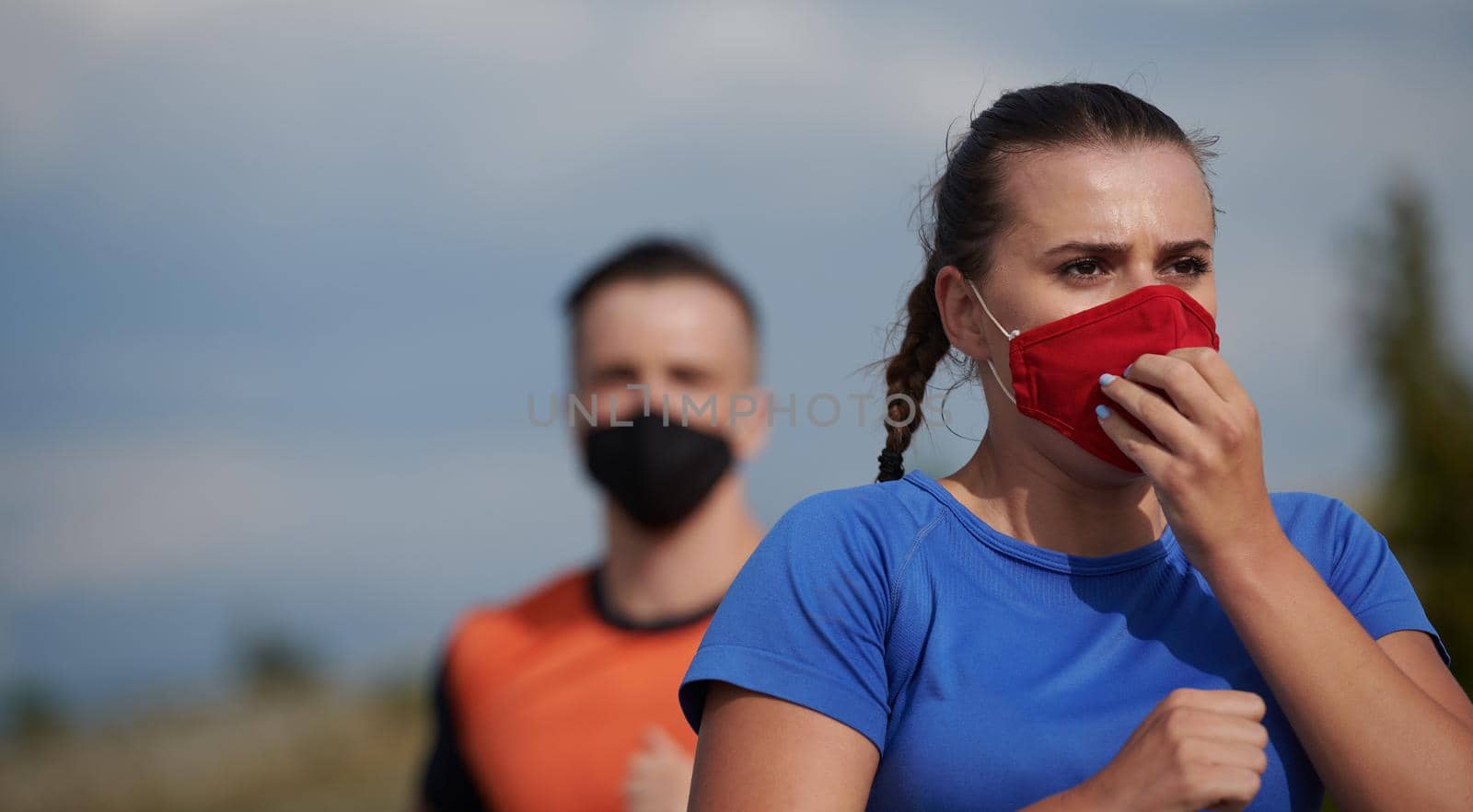 couple of running in nature wearing mask having a break by dotshock