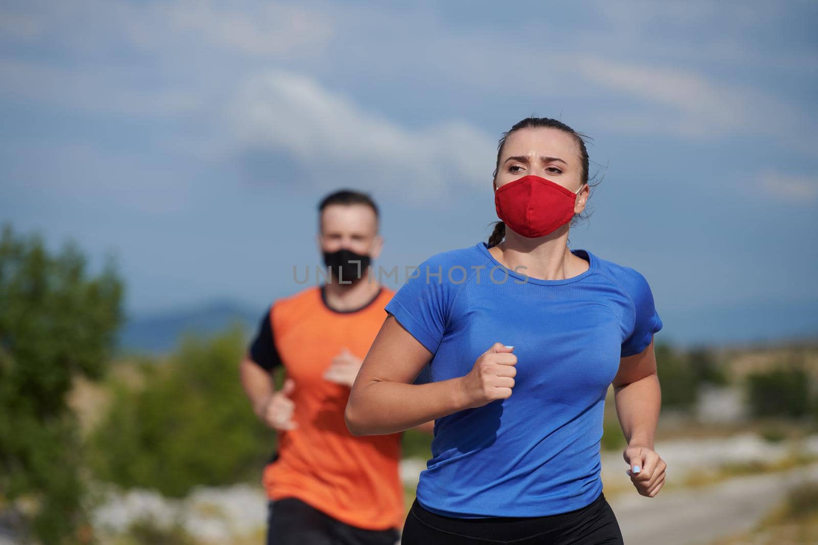 couple running in nature wearing mask by dotshock