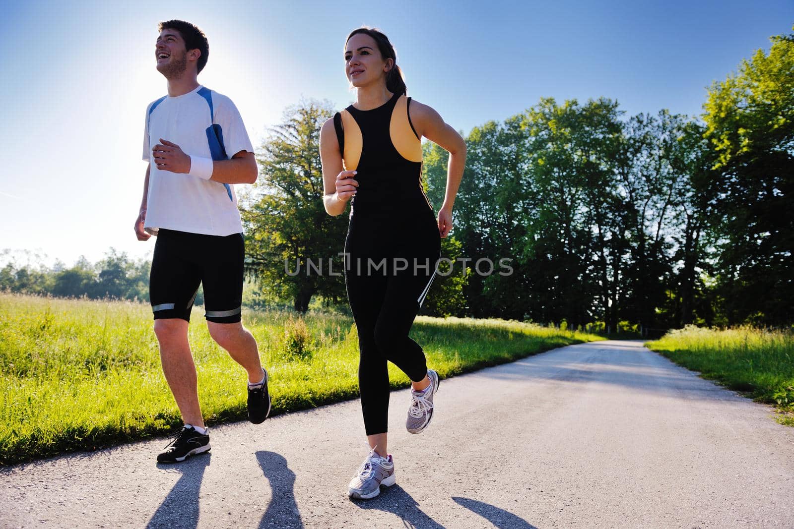 Young couple jogging in park at morning. Health and fitness.