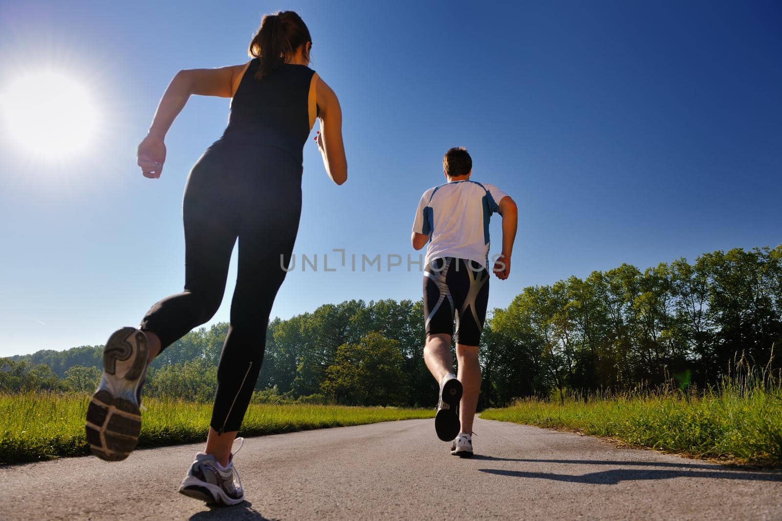 Young couple jogging in park at morning. Health and fitness.