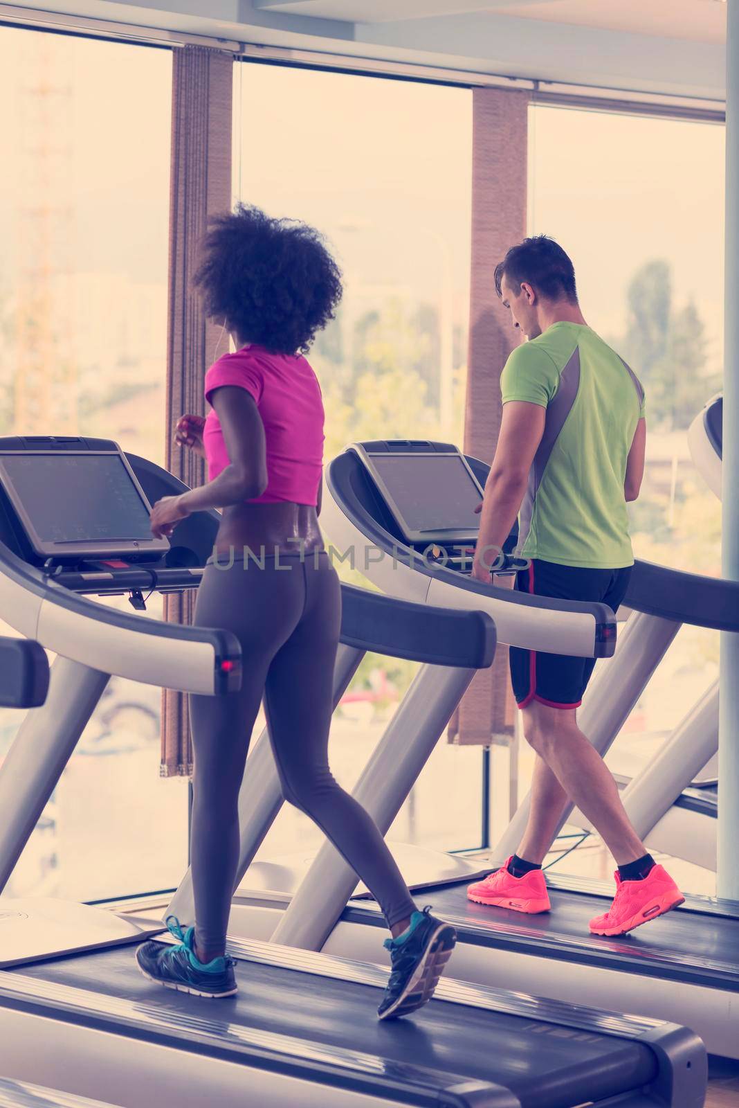 young people exercisinng a cardio on treadmill running machine in modern gym