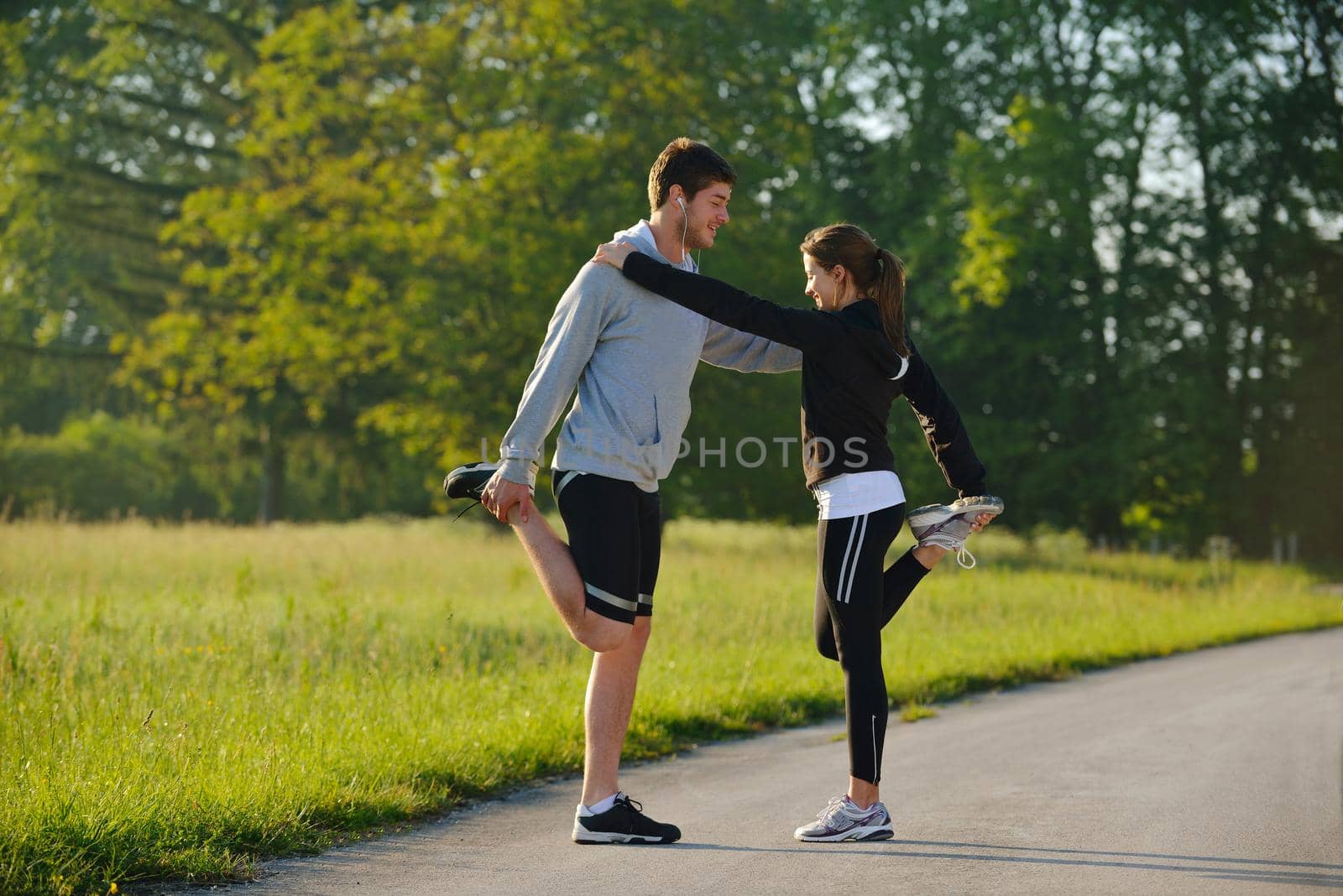 young health couple doing stretching exercise relaxing and warm up after jogging and running in park