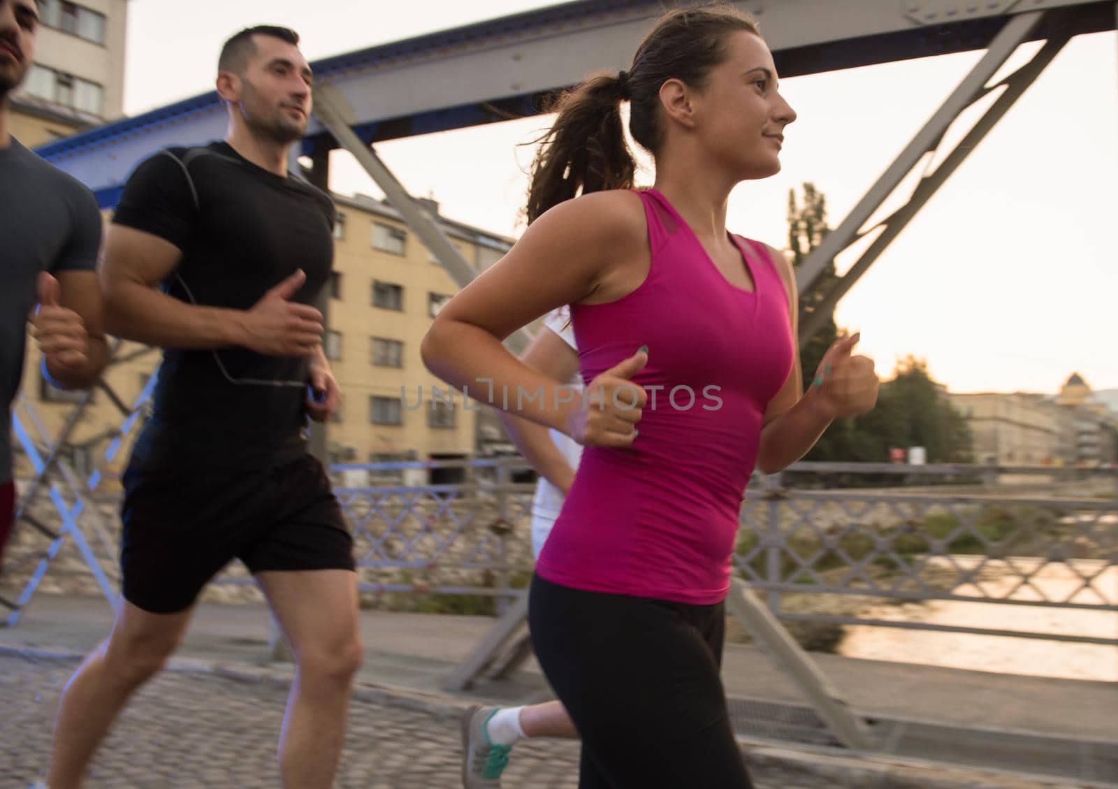 group of young people jogging across the bridge by dotshock