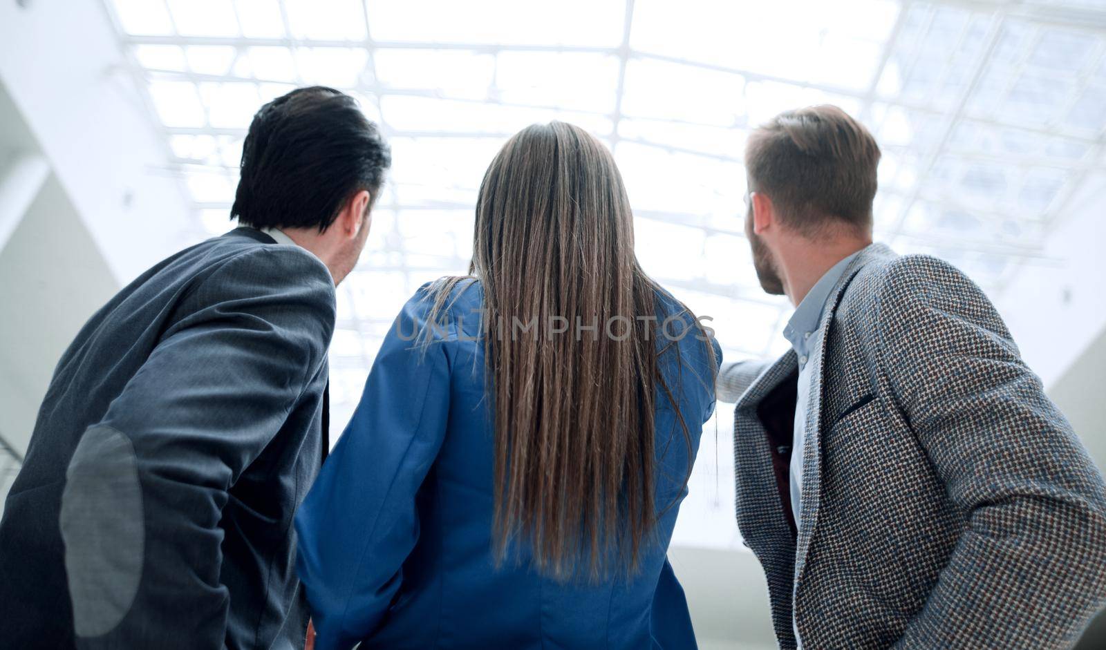 rear view.a group of business colleagues standing in the office by asdf