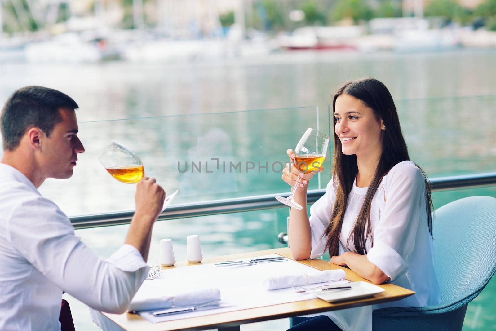 happy young couple having lanch at beautiful restaurant on by the sea on  beach