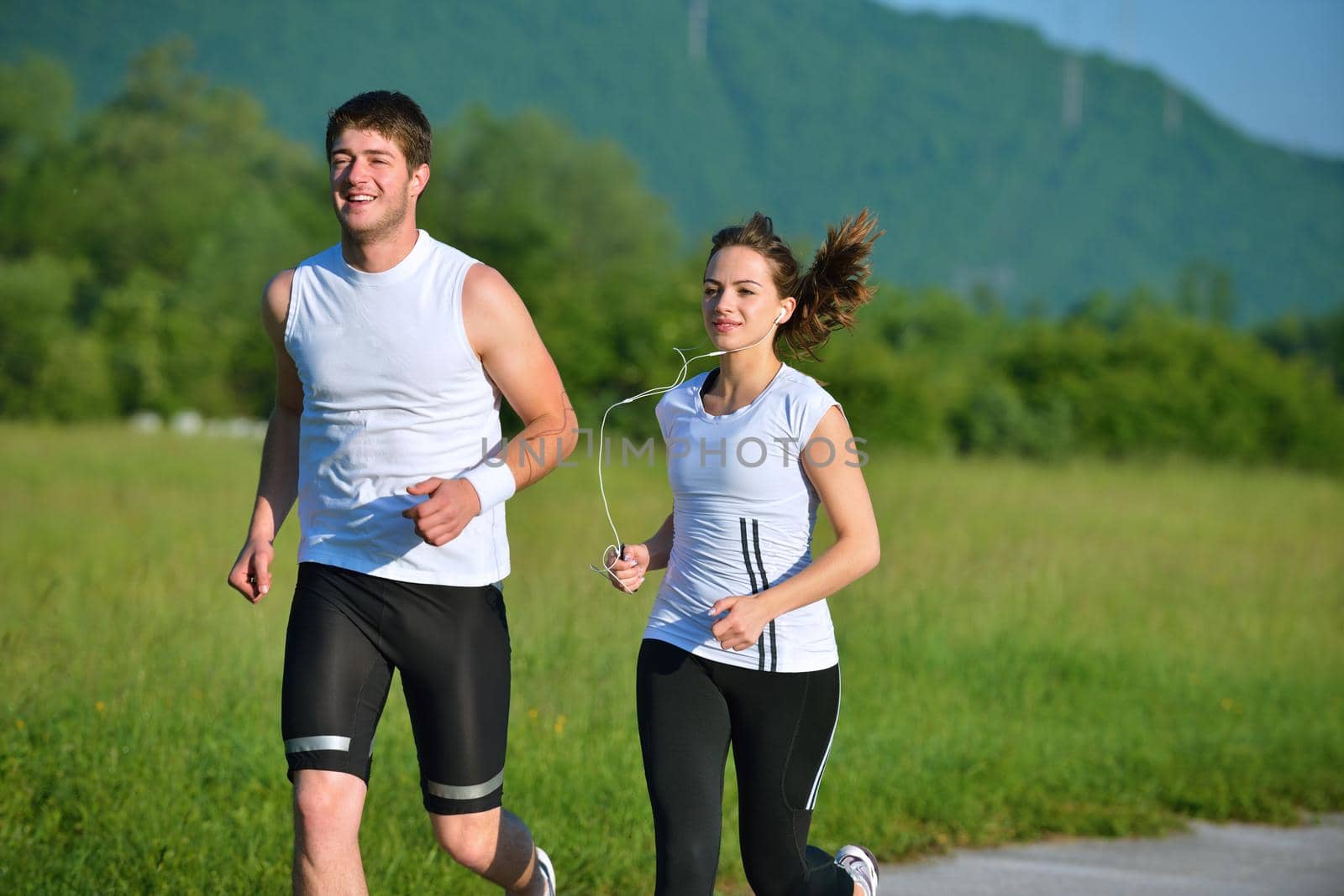 Young couple jogging in park at morning. Health and fitness concept