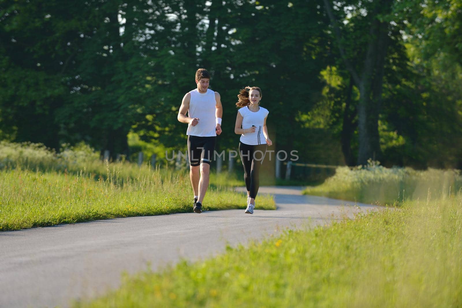 Young couple jogging in park at morning. Health and fitness.