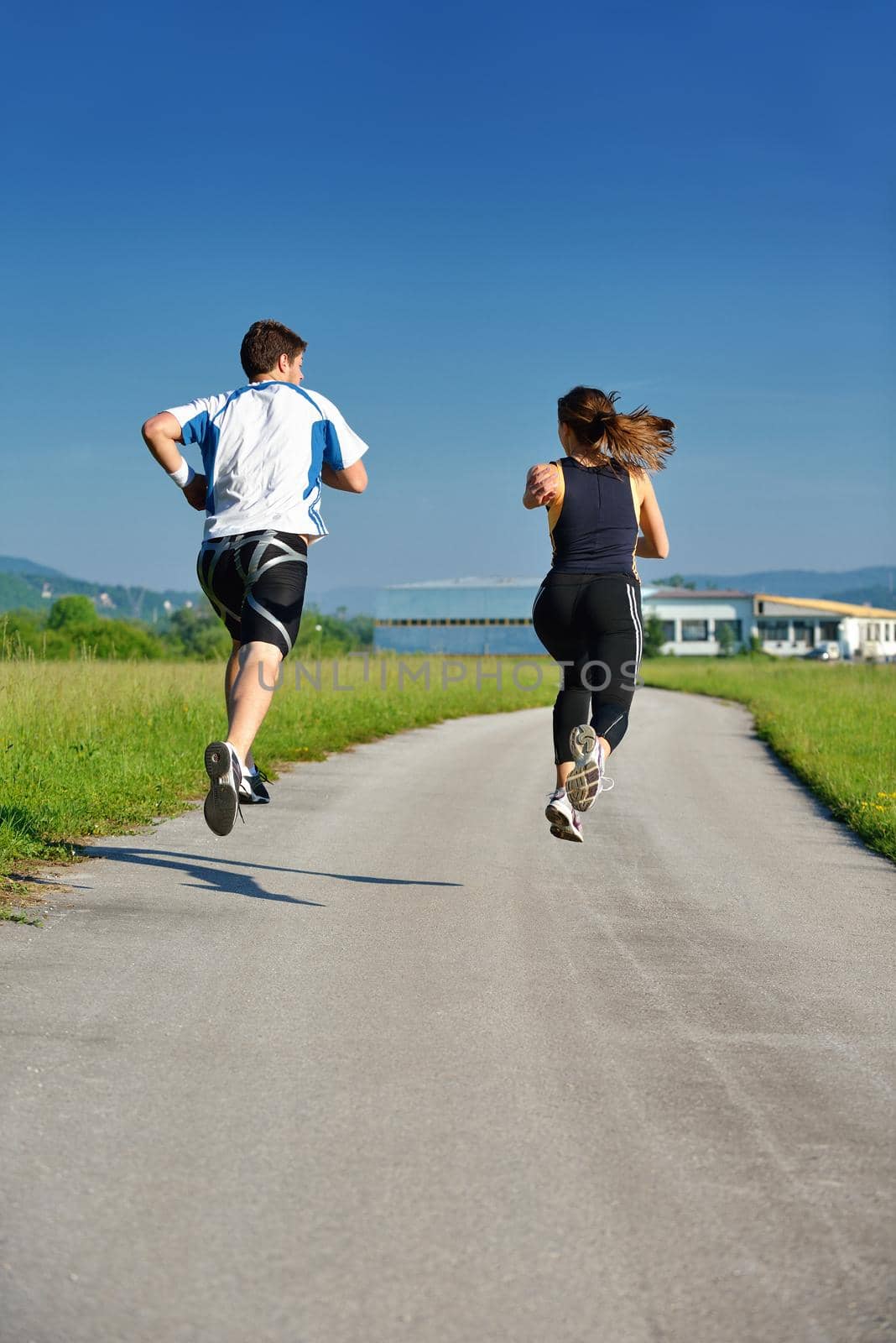 Young couple jogging in park at morning. Health and fitness concept