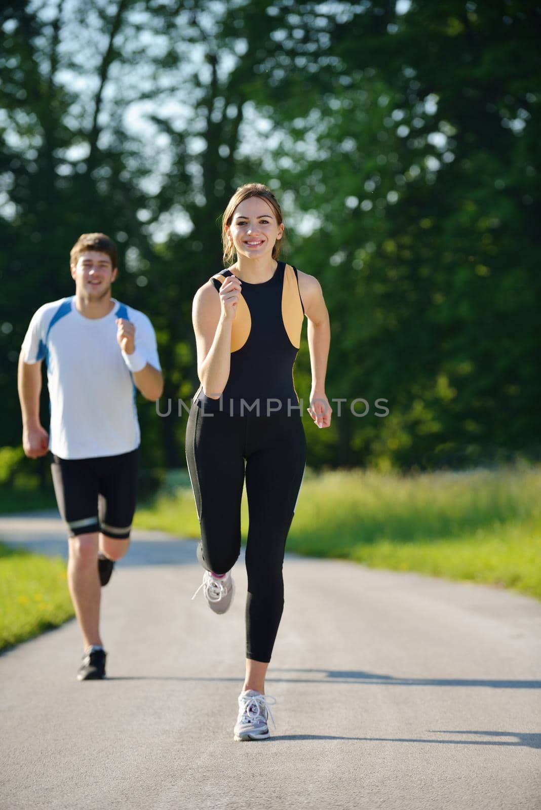 Young couple jogging in park at morning. Health and fitness concept