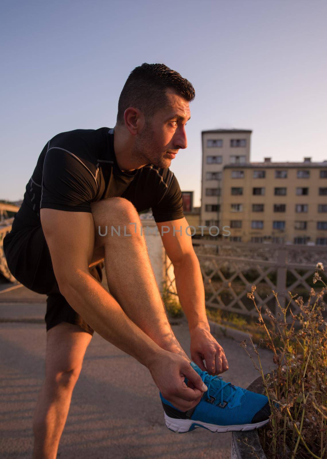 man tying running shoes laces by dotshock