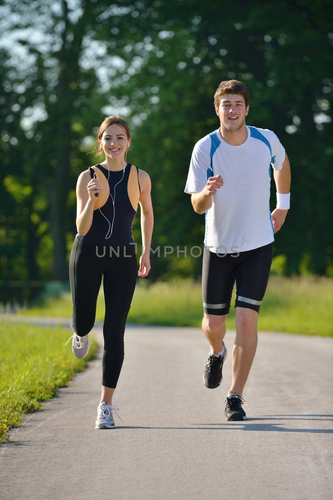 Young couple jogging in park at morning. Health and fitness concept