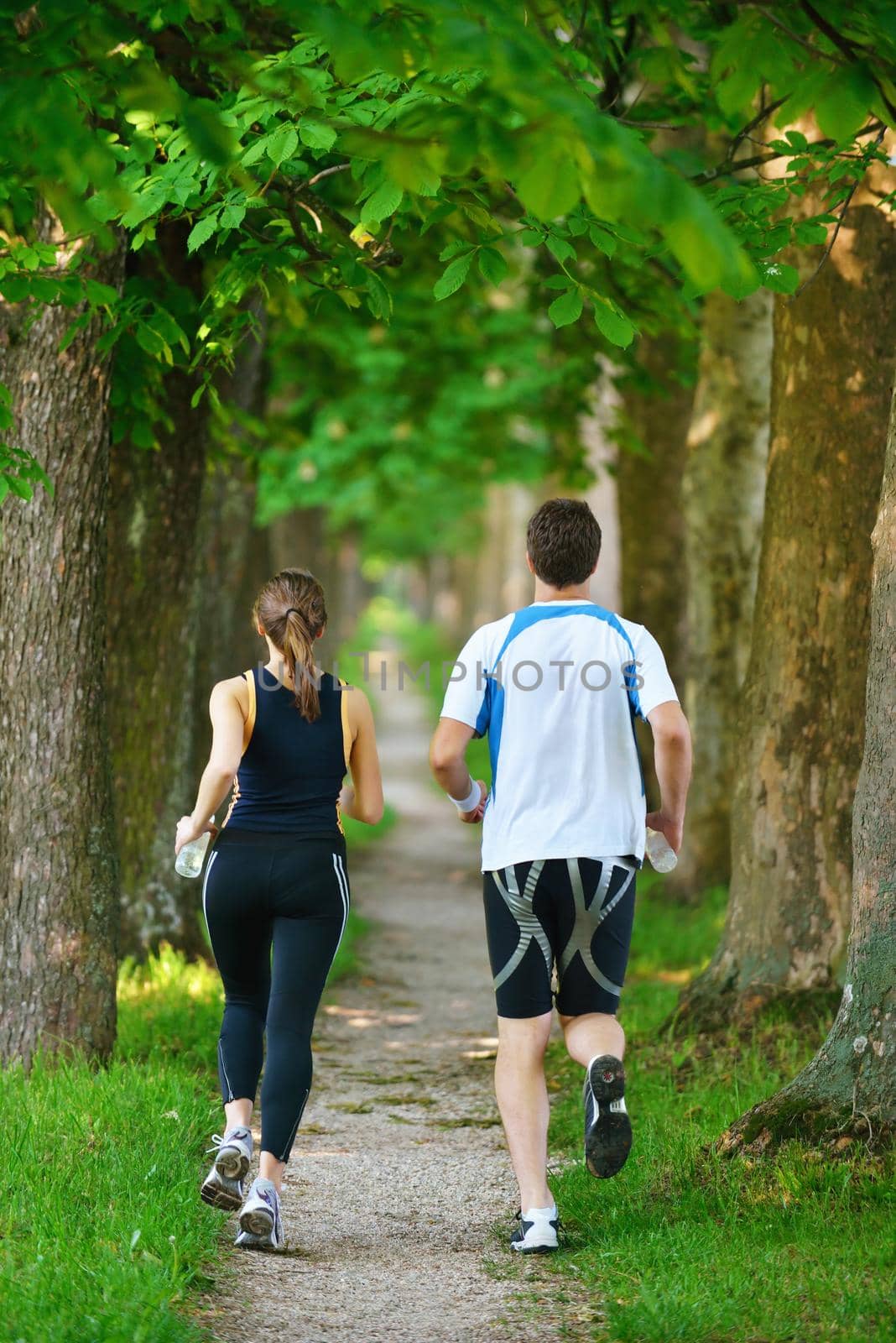 Young couple jogging in park at morning. Health and fitness.