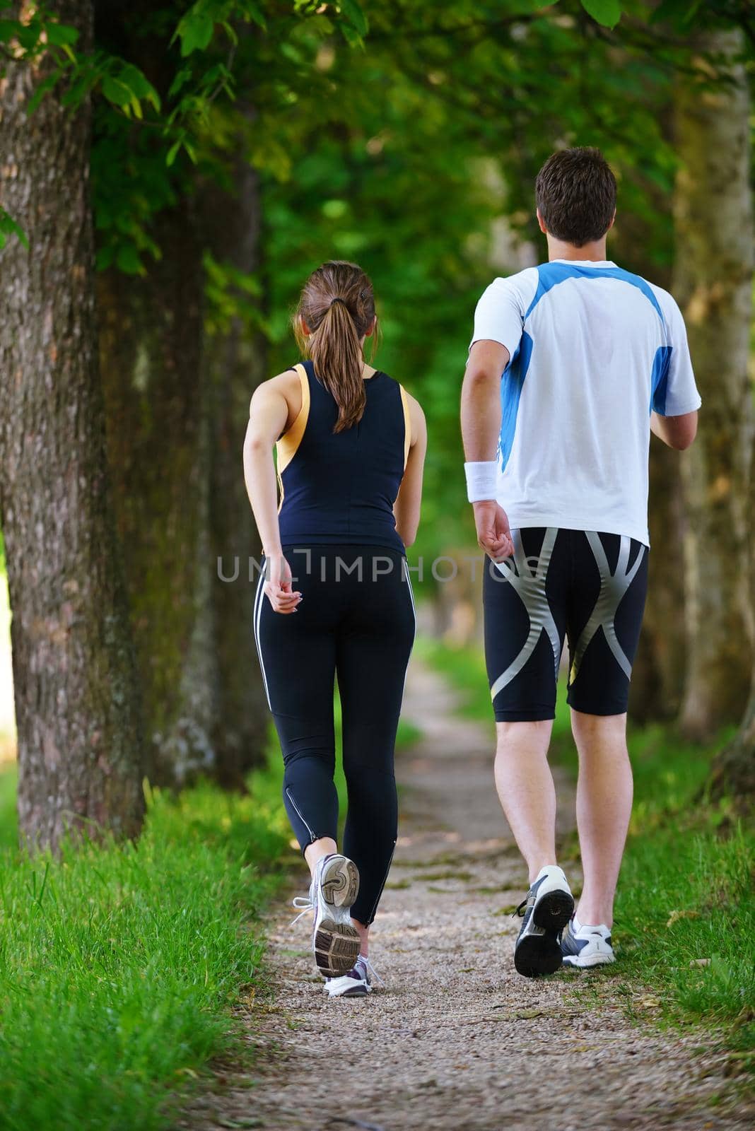 Young couple jogging in park at morning. Health and fitness.