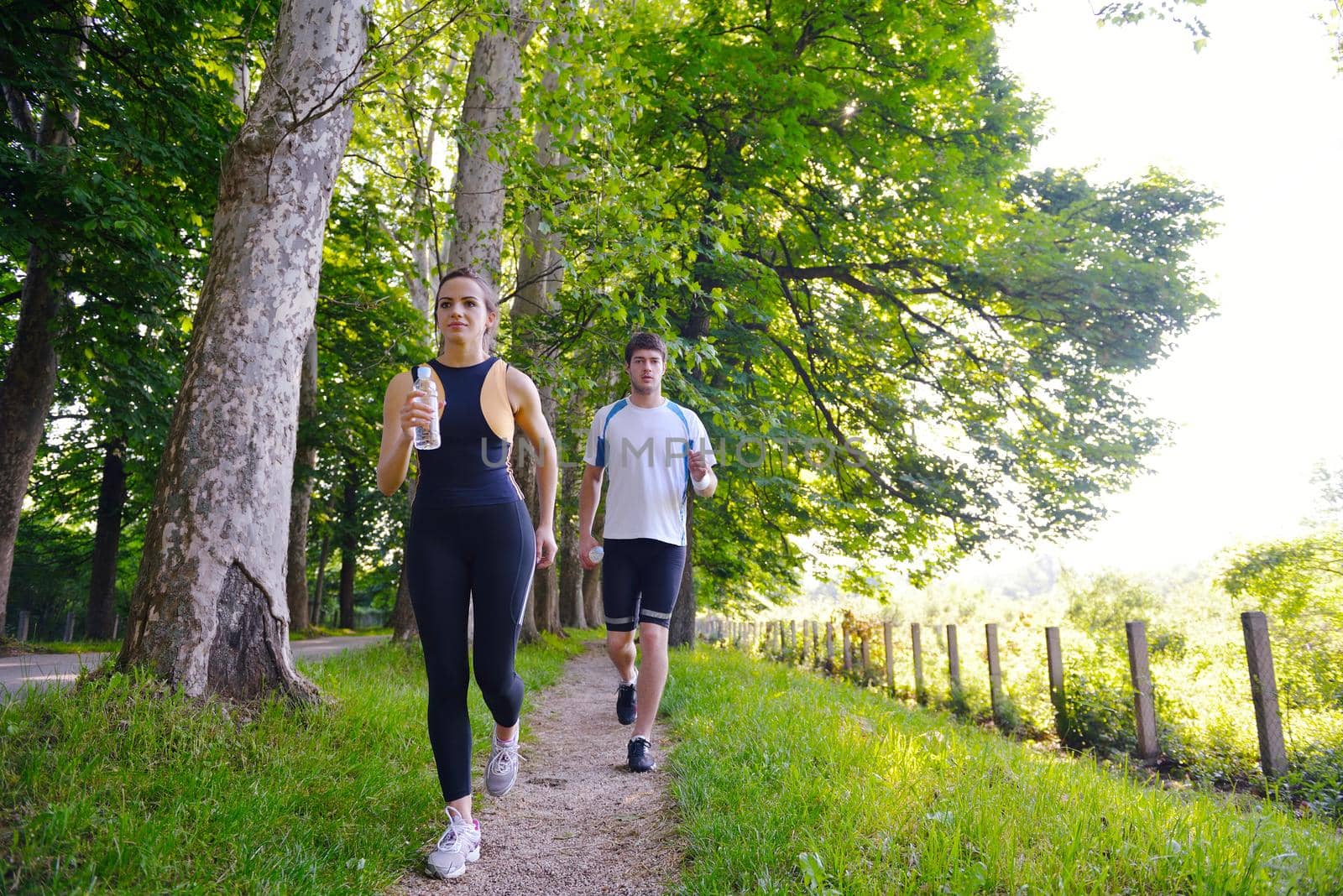 Young couple jogging in park at morning. Health and fitness.