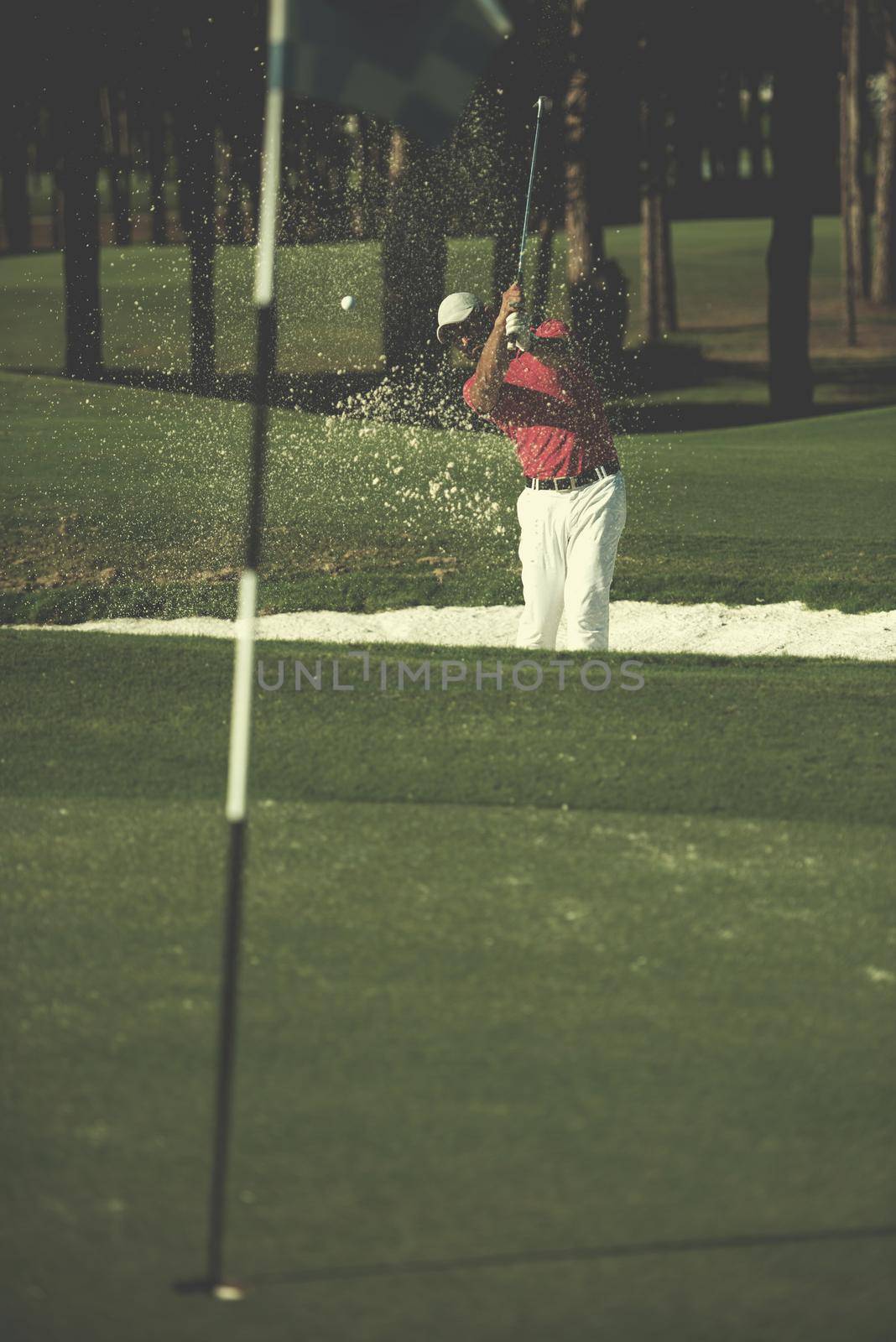 golf player shot ball from sand bunker at course