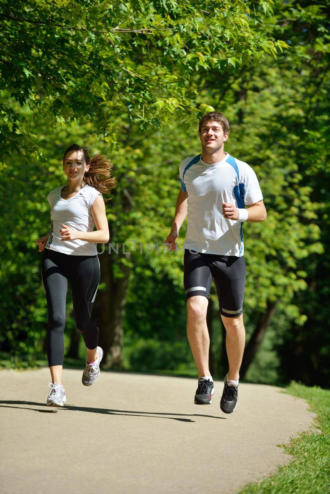 Young couple jogging in park at morning. Health and fitness.