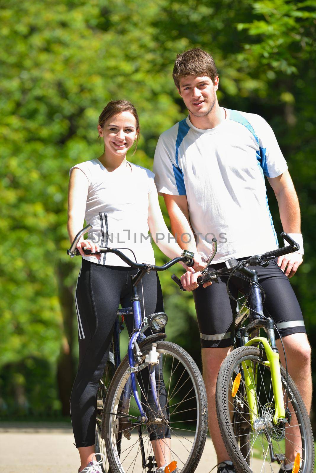 Happy couple riding bicycle outdoors by dotshock