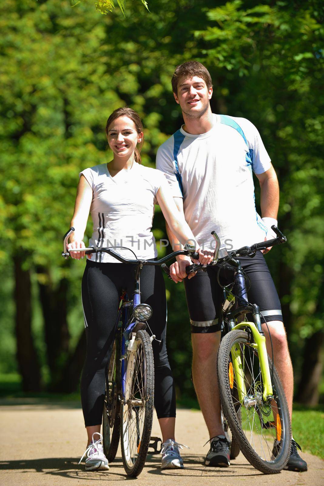 Happy couple riding bicycle outdoors by dotshock