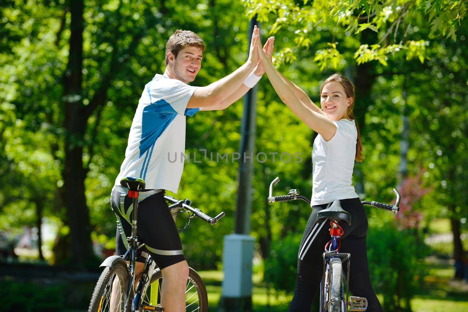 Happy couple riding bicycle outdoors, health lifestyle fun love romance concept