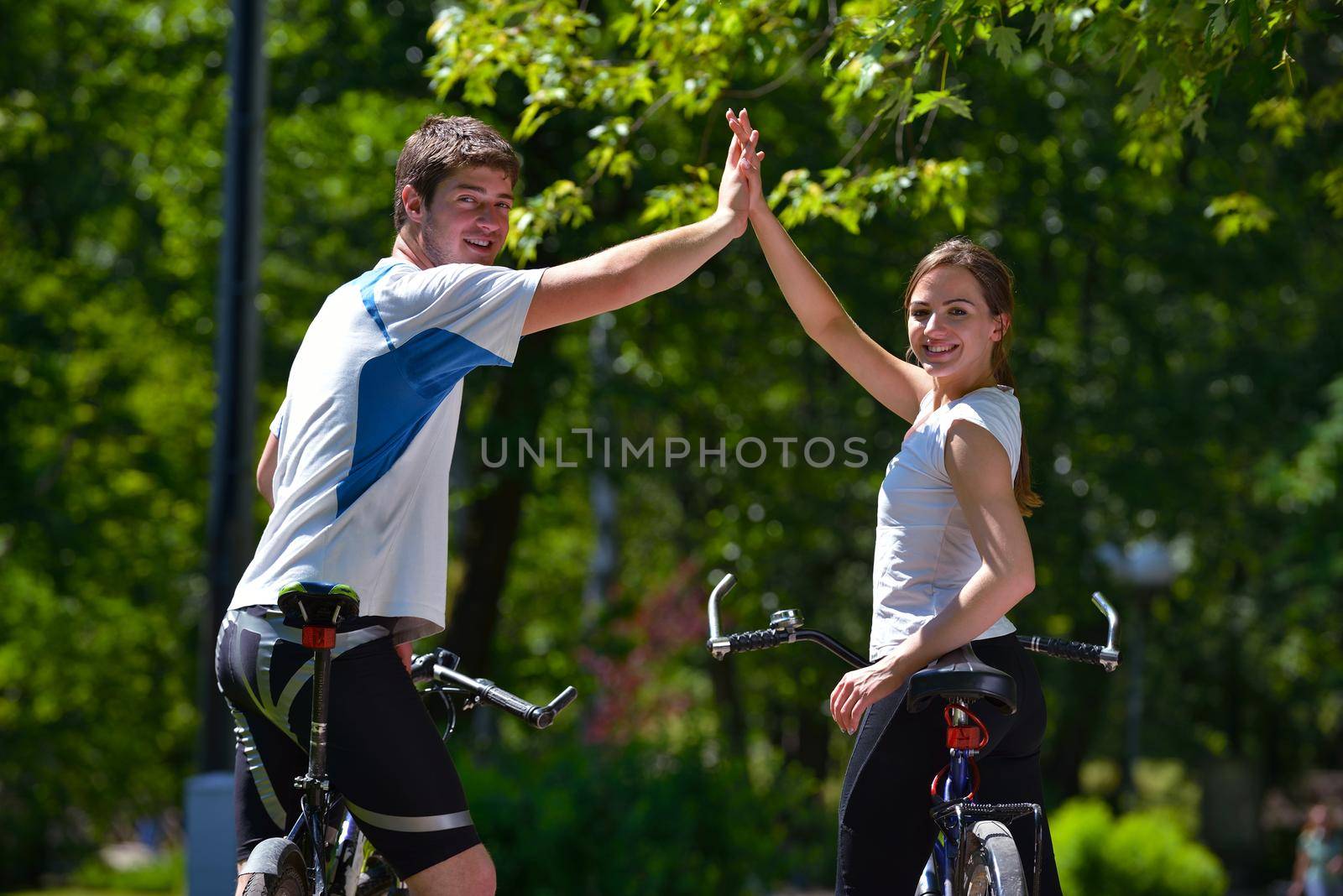 Happy couple ridine bicycle outdoors by dotshock