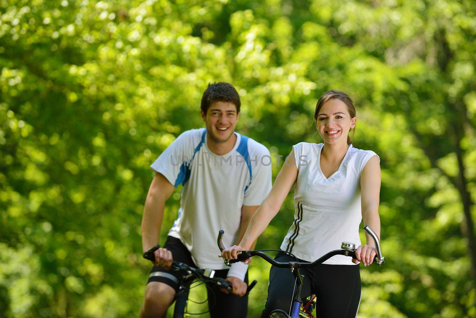 Happy couple riding bicycle outdoors by dotshock