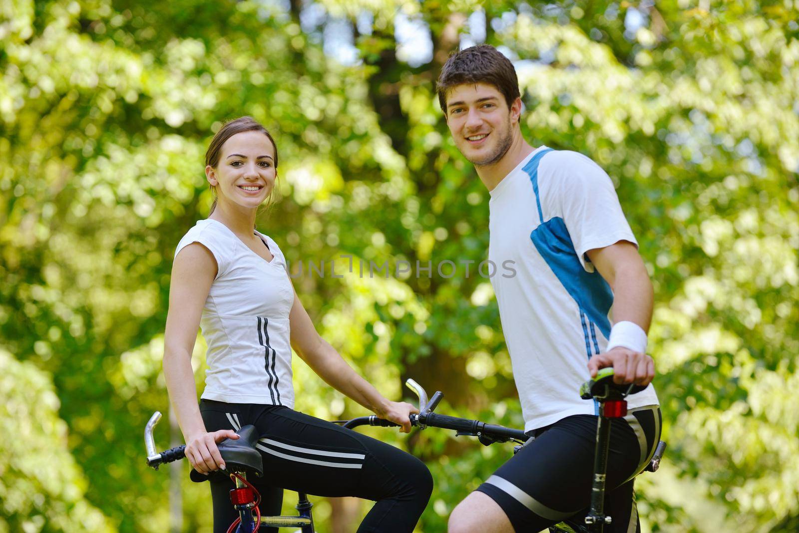 Happy couple riding bicycle outdoors by dotshock