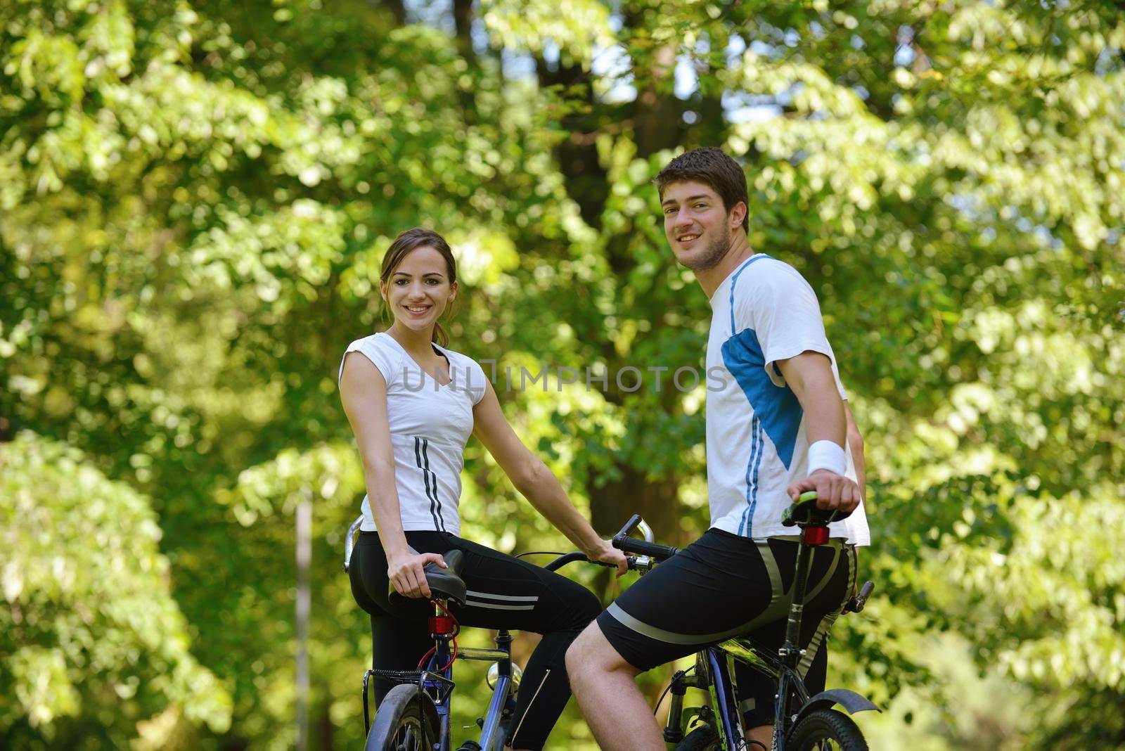 Happy couple riding bicycle outdoors by dotshock