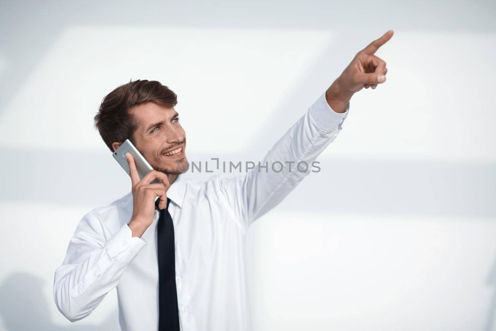 young man talking on the phone is pointing up at something by asdf