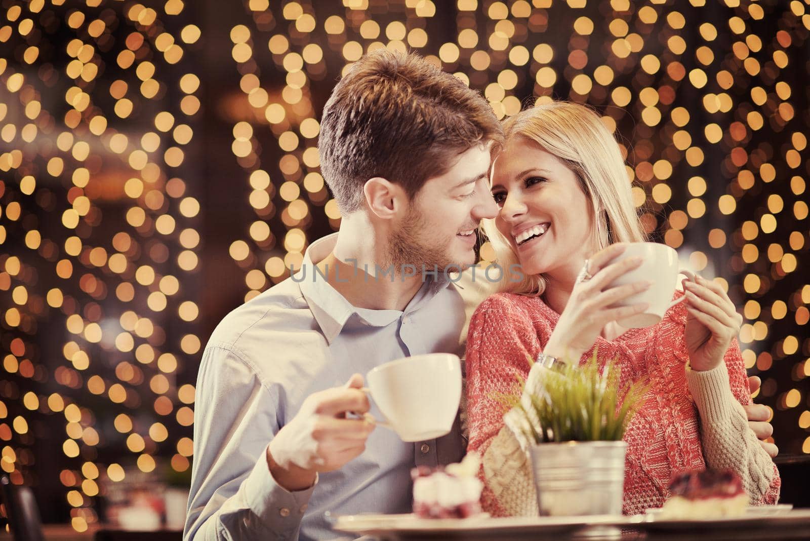 romantic evening date in restaurant  happy young couple with wine glass tea and cake