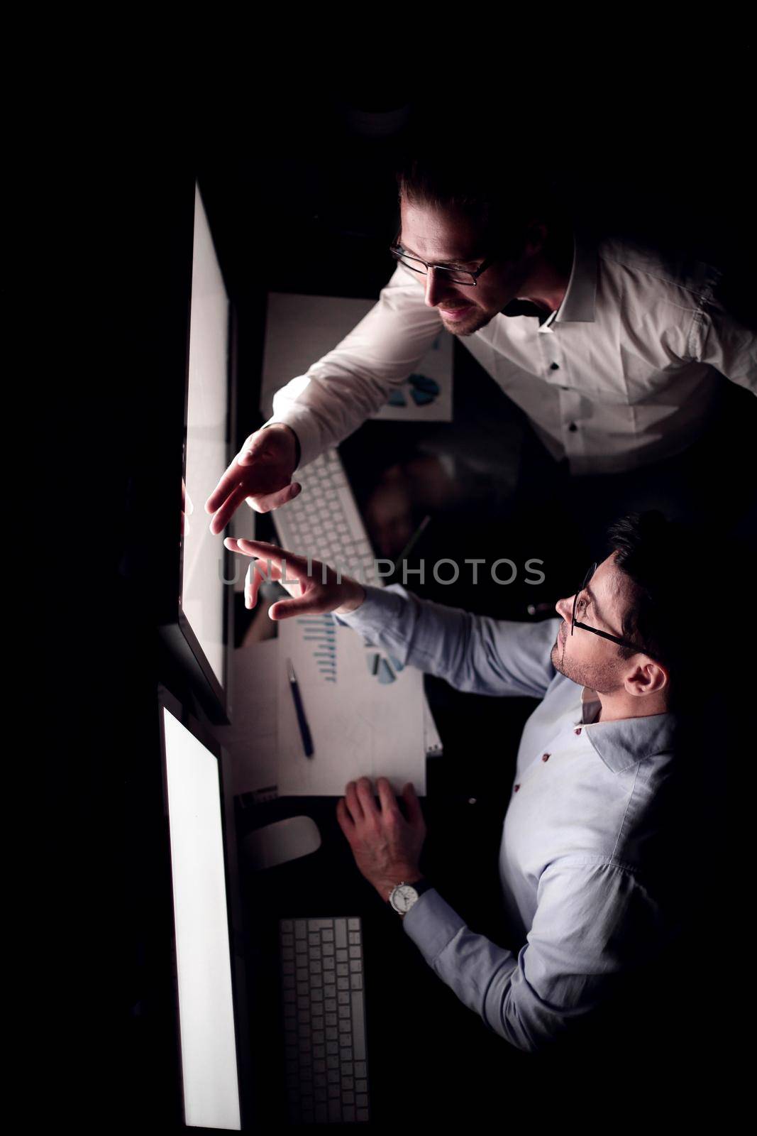 top view .business colleagues discussing information on the computer screen by asdf