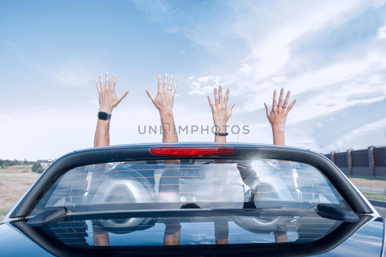 group of happy young people waving from a convertible car.photo with copy space