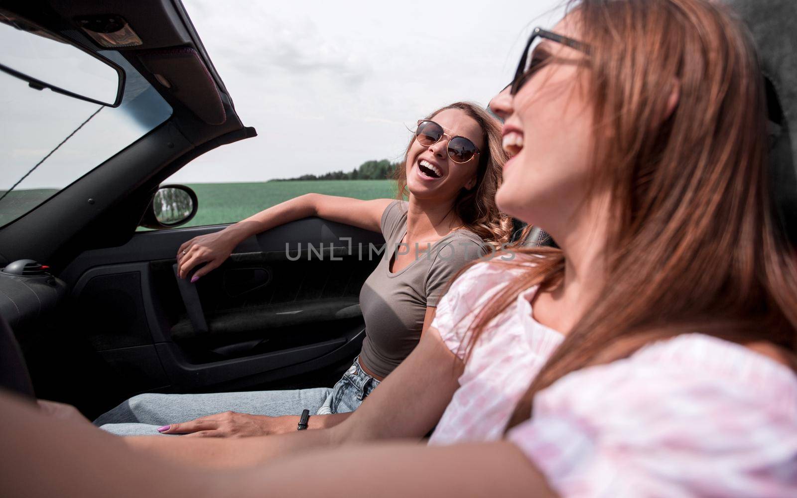 close up.two cheerful young women travel by car. by asdf