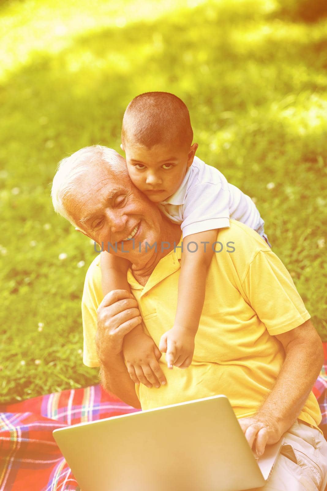 grandfather and child using laptop by dotshock