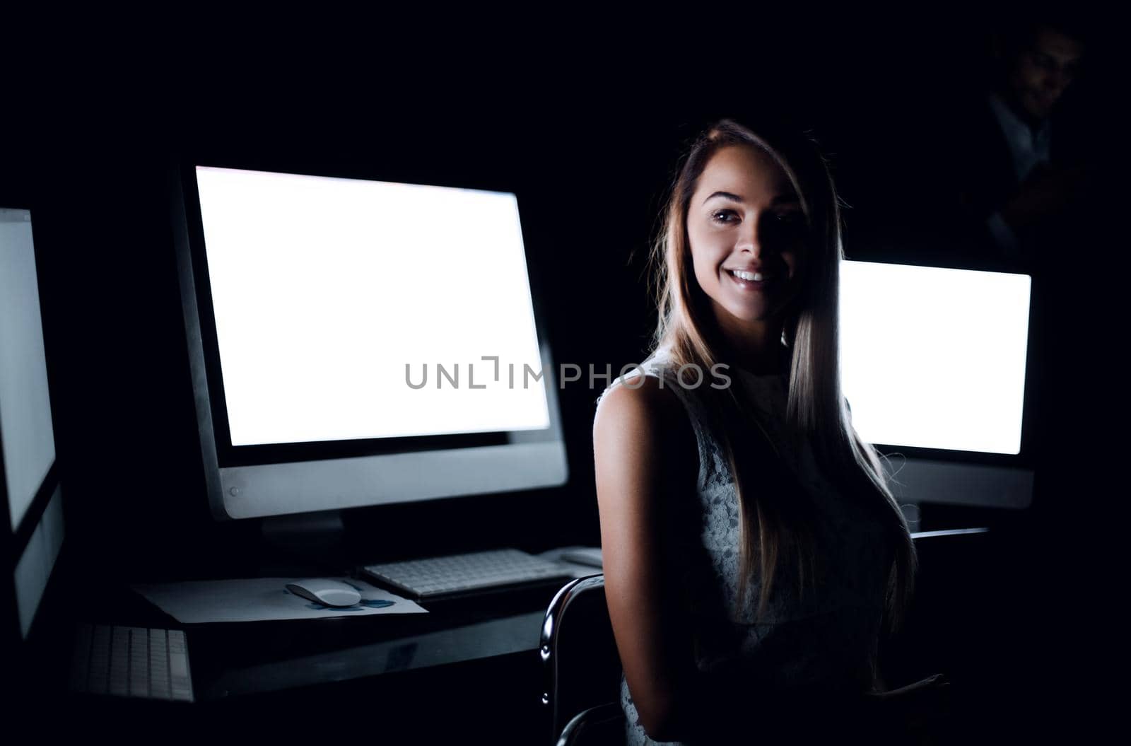 young employee sitting in computer room at night by asdf