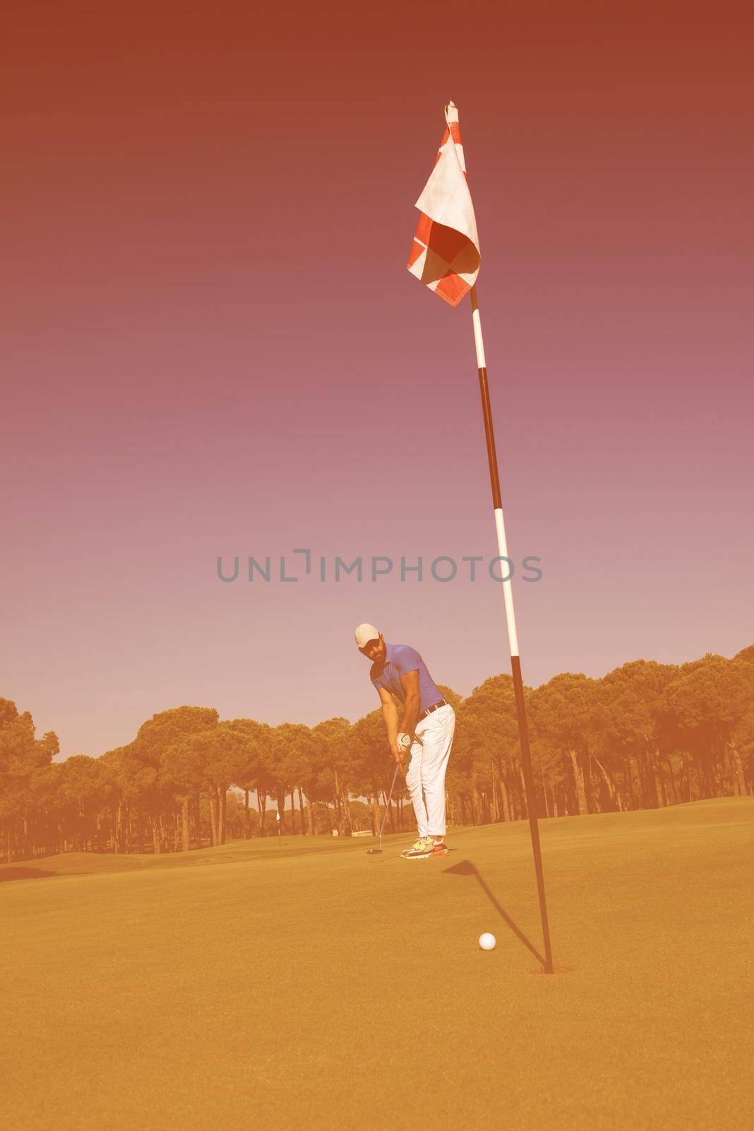 golf player hitting shot at sunny day by dotshock