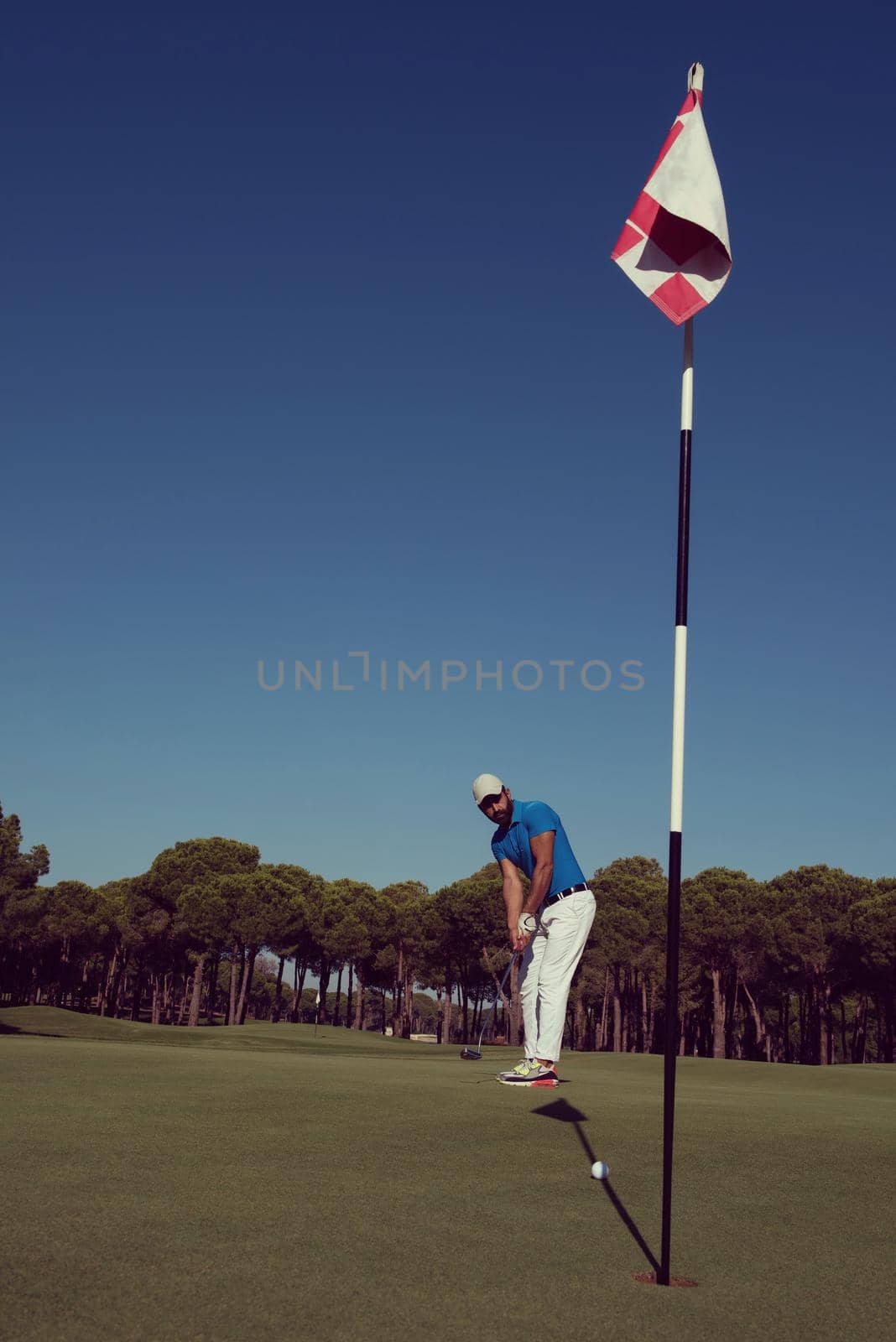 golf player hitting shot at sunny day by dotshock