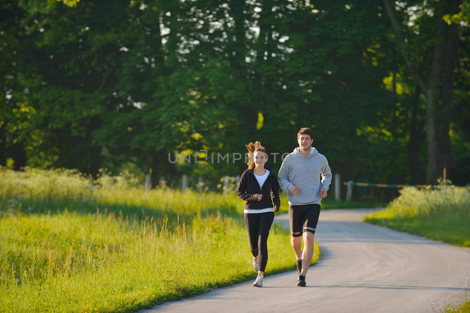 Young couple jogging in park at morning. Health and fitness.