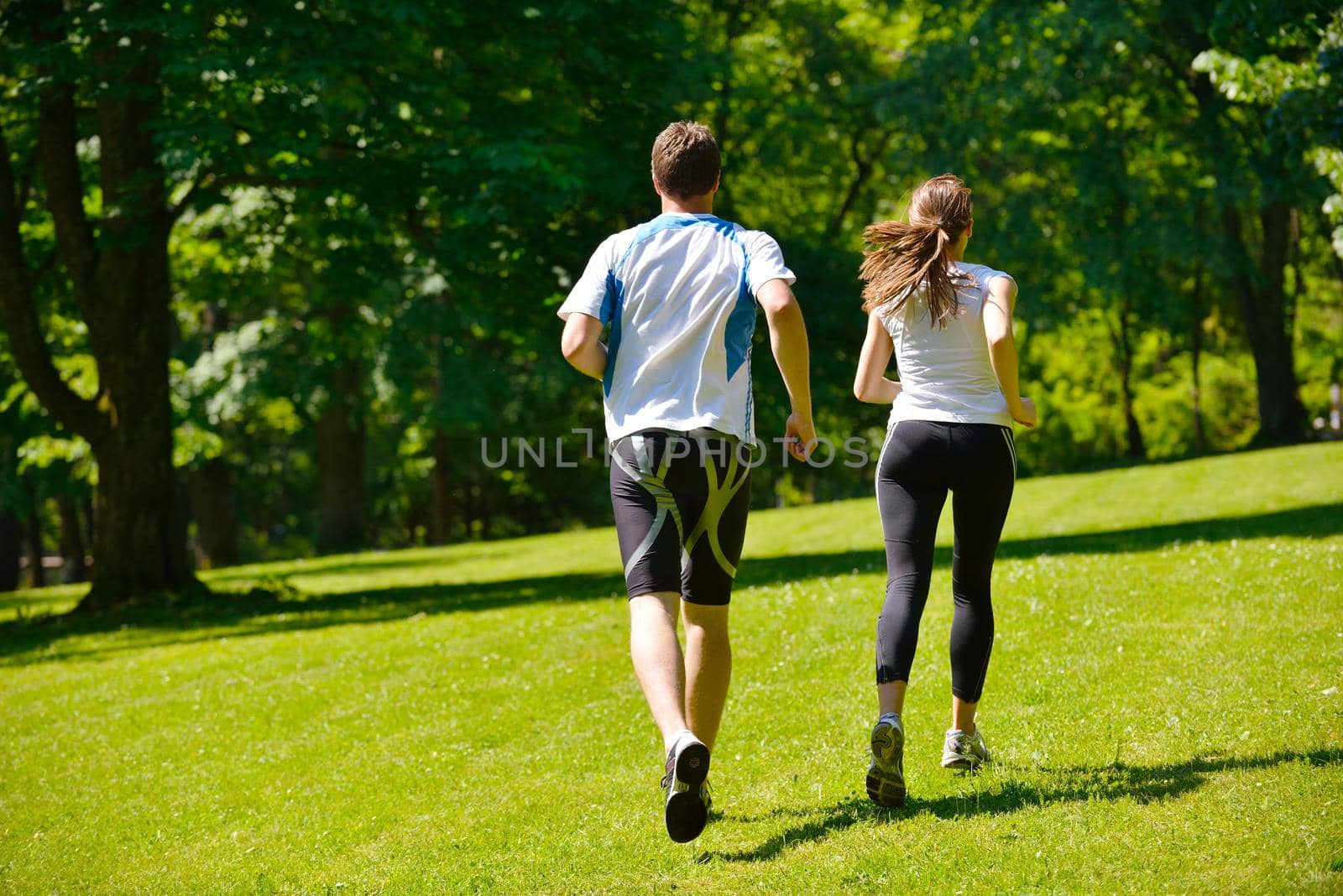 Young couple jogging in park at morning. Health and fitness.