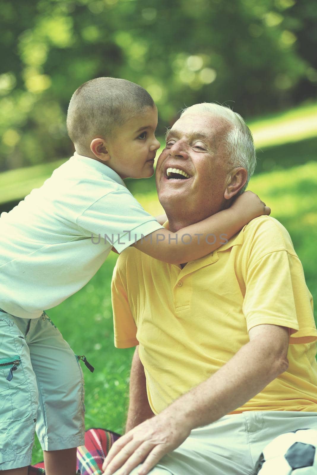 happy grandfather and child have fun and play in park