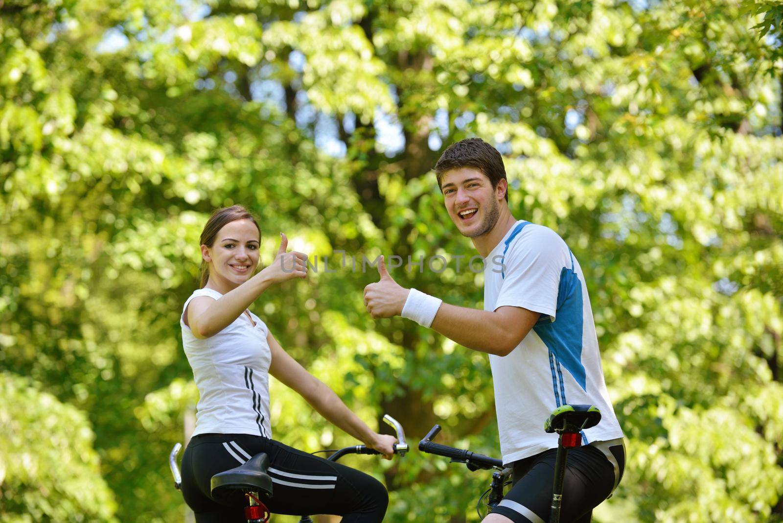 Happy couple riding bicycle outdoors by dotshock