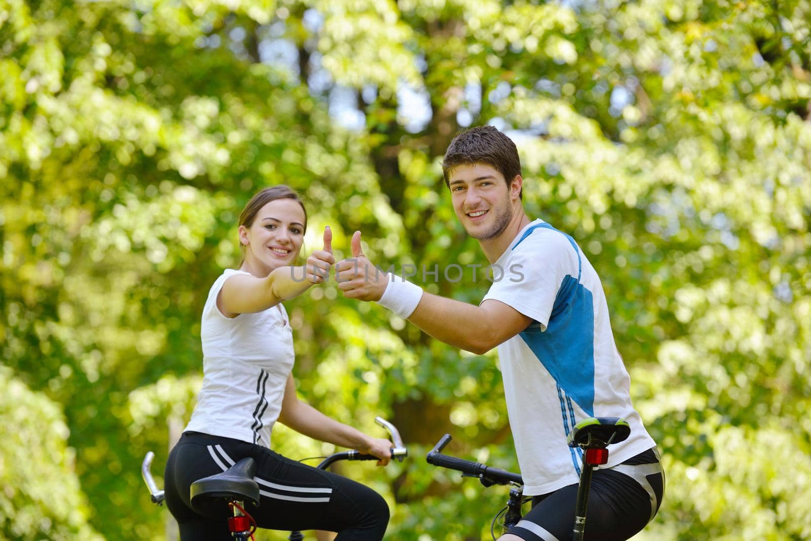 Happy couple riding bicycle outdoors by dotshock