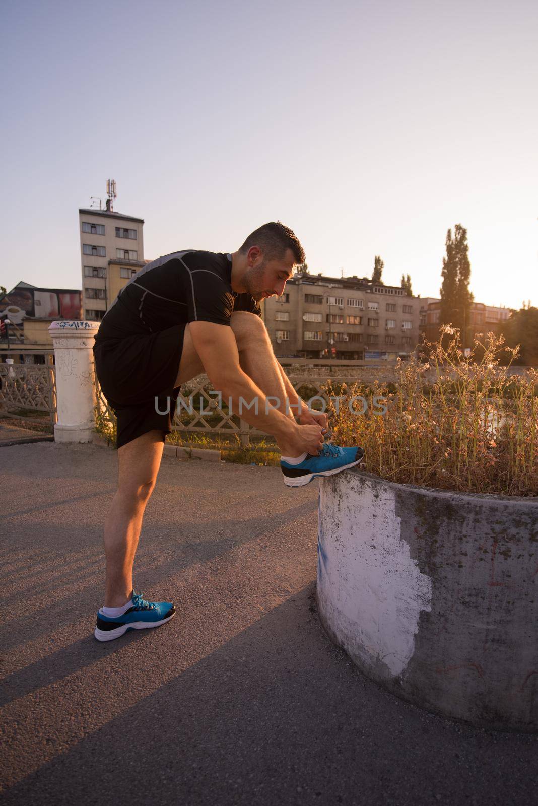 man tying running shoes laces by dotshock