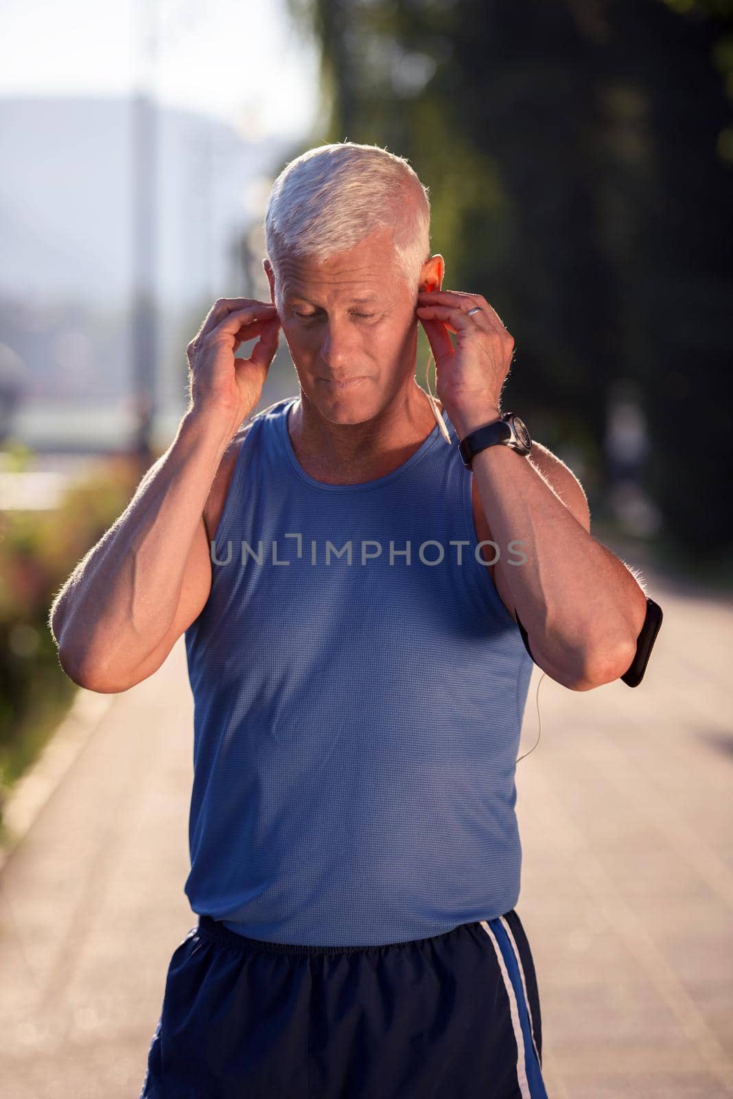 portrait of handsome senior jogging man while relaxing  and take break after morning run