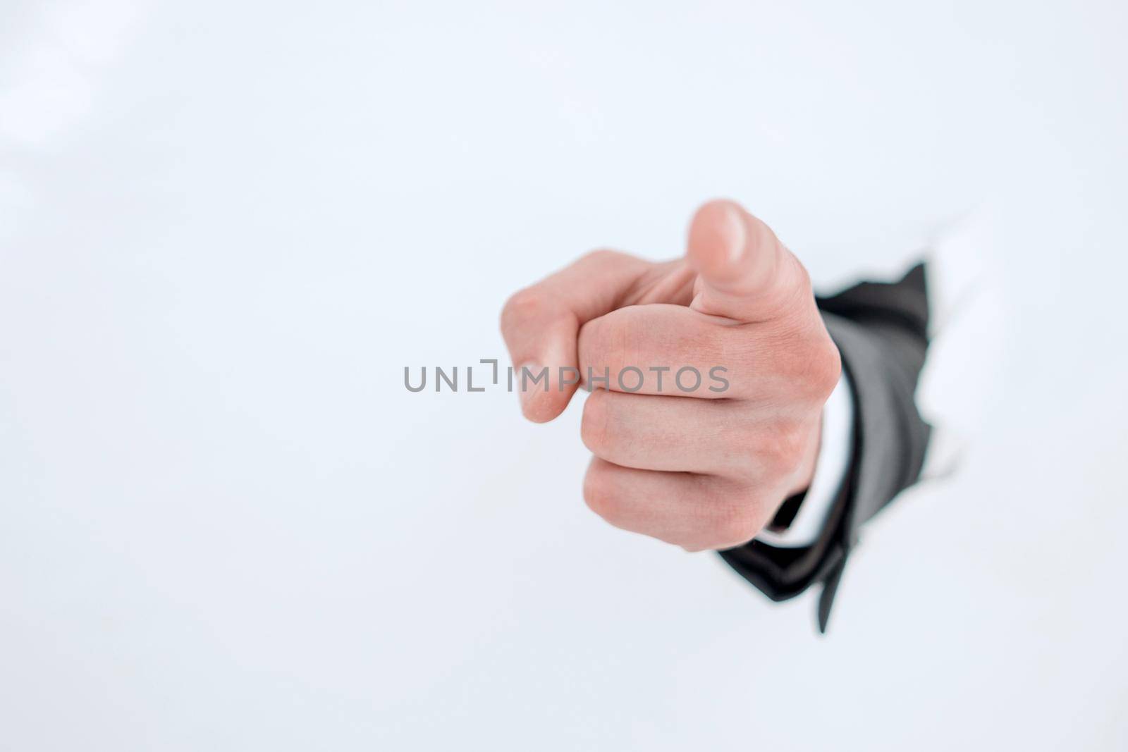 businessman breaking through the paper wall and pointing at you.photo with copy space