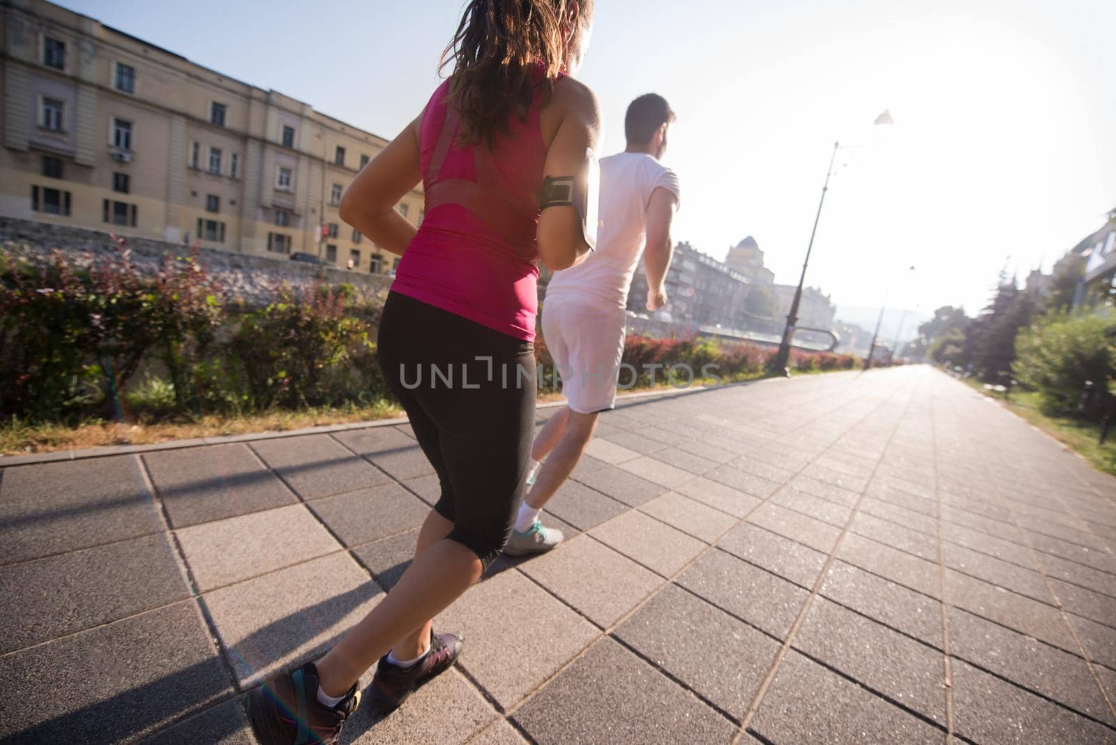 urban sports, healthy young couple jogging  in the city at sunny morning