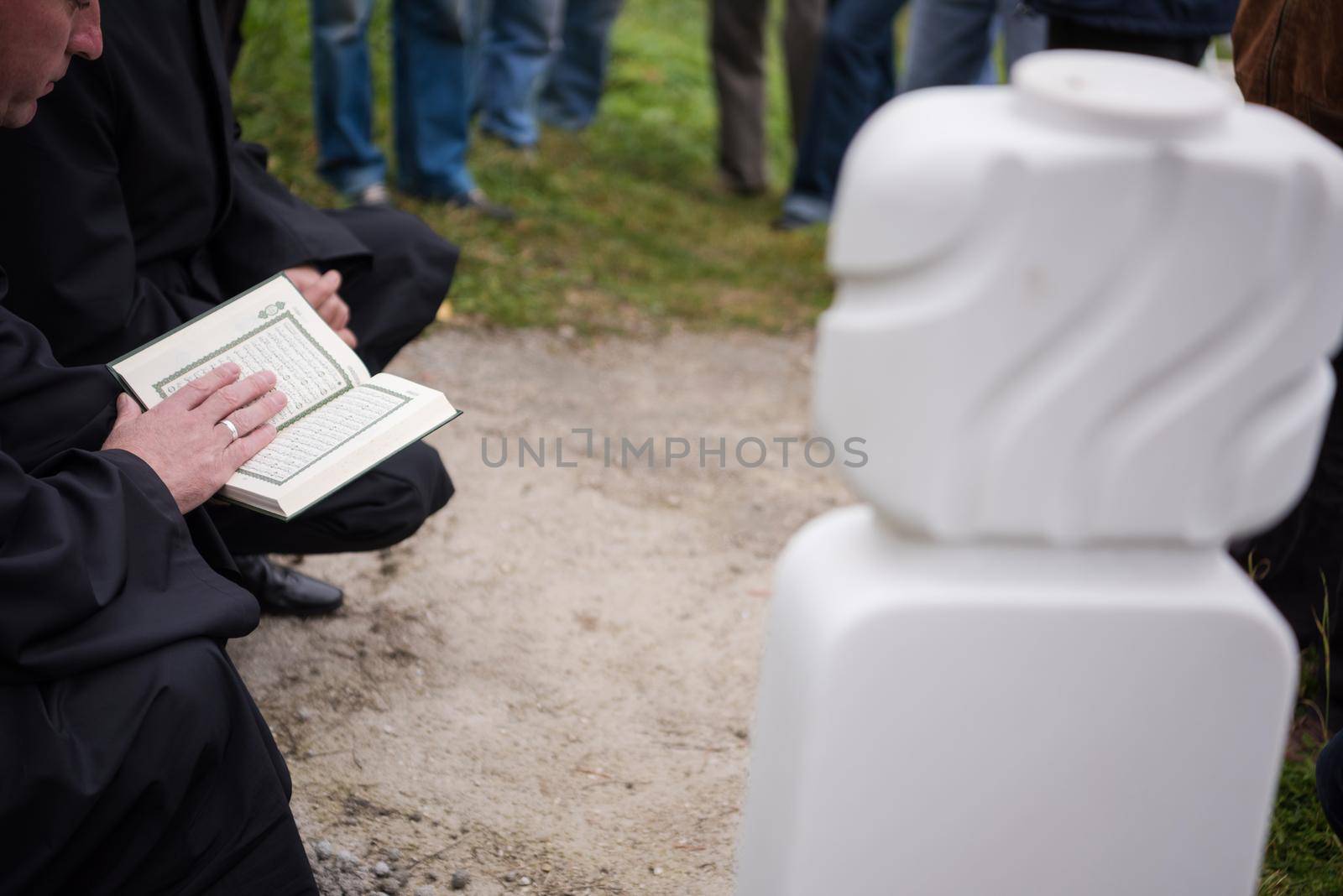 quran holy book reading by imam  on islamic funeral with white thumb stones graweyard background