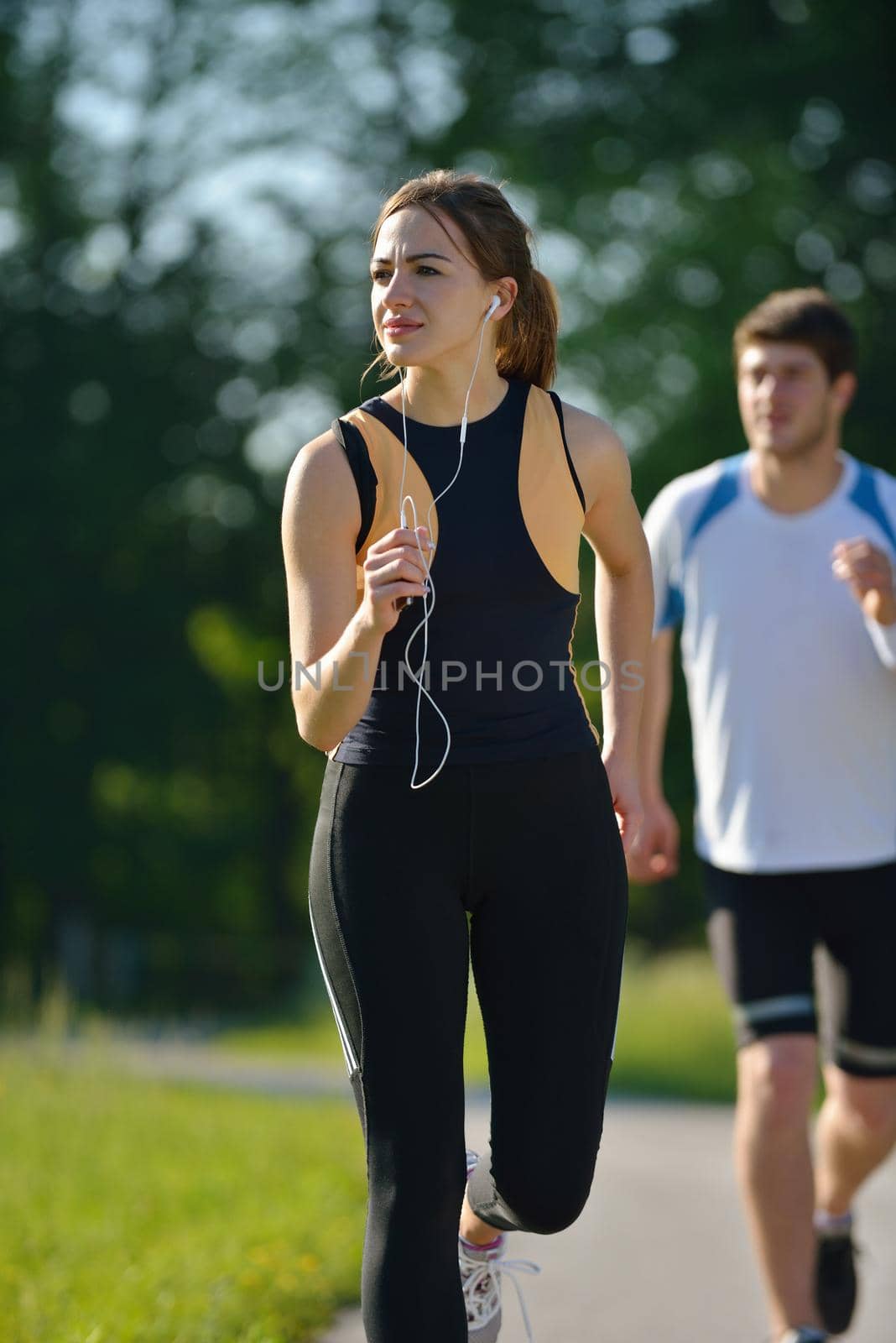 Young couple jogging in park at morning. Health and fitness concept